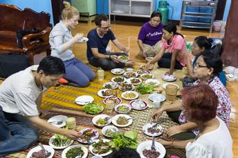 people eating Isan food while sitting on the floor