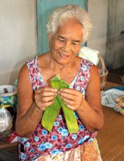 woman folding banana leaves