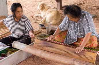 woman weaving a sitting mat